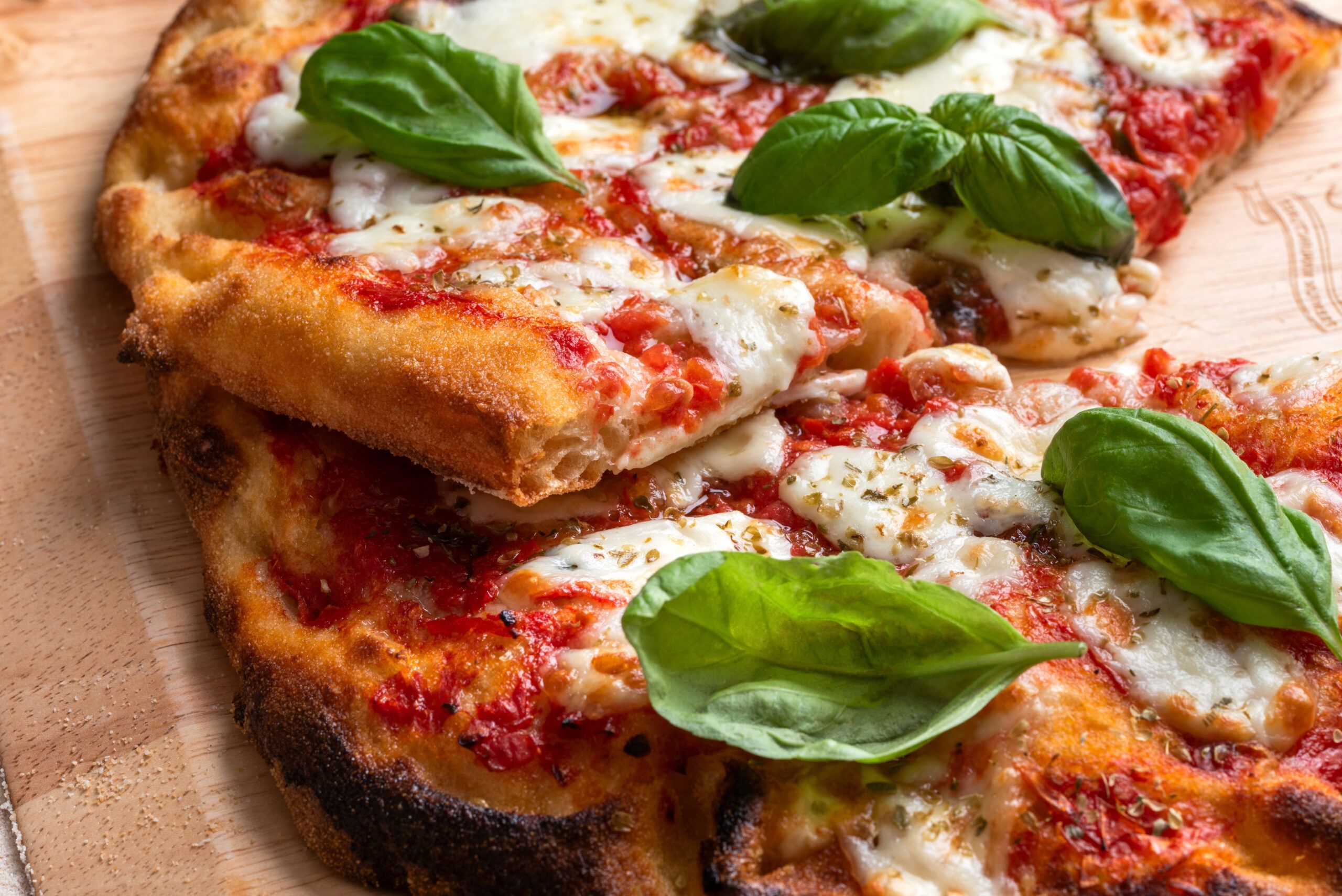 Pinsa romana condita con sugo, mozzarella e basilico, cibo italiano